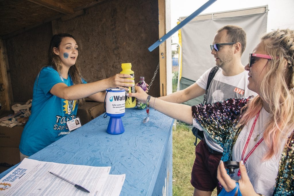 81932 A WaterAid volunteer refilling a water bottle at Glastonbury
